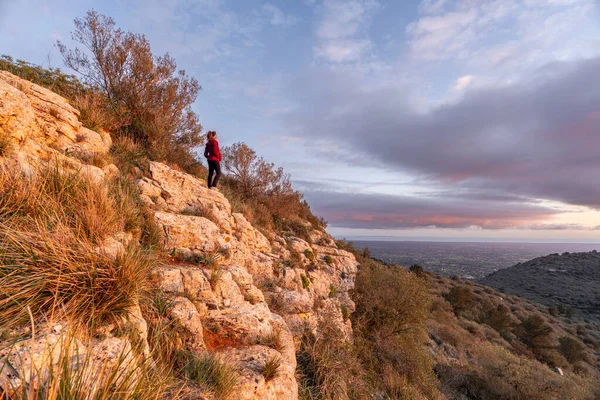 A person balancing on one leg in a bright space.